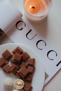 Minimalist photo showing a luxury hotel turndown service setup with a personalized chocolate amenity on the pillow