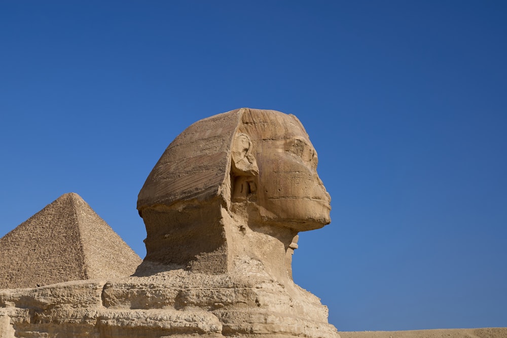 the sphinx and pyramids of giza against a blue sky