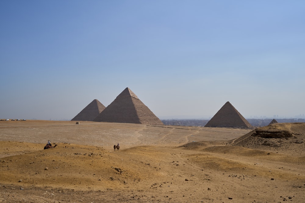 três pirâmides no deserto com um fundo do céu