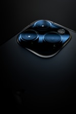 A close-up of a smartphone camera lens with natural light reflections.