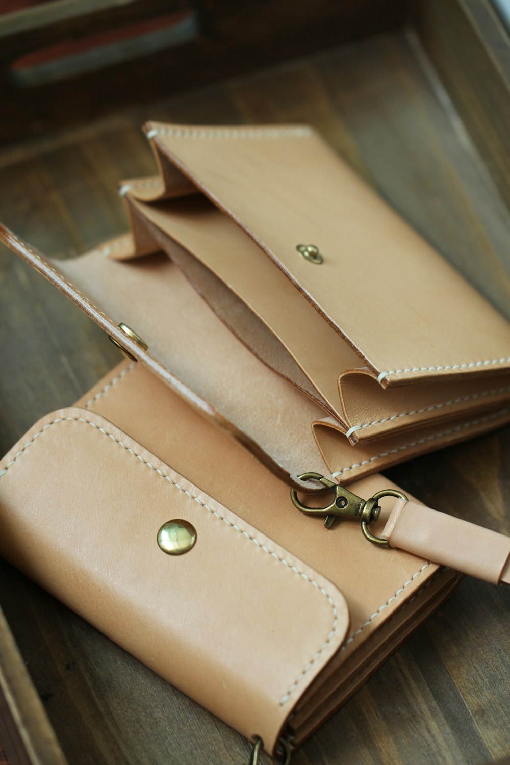 a pair of wallets sitting on top of a wooden table