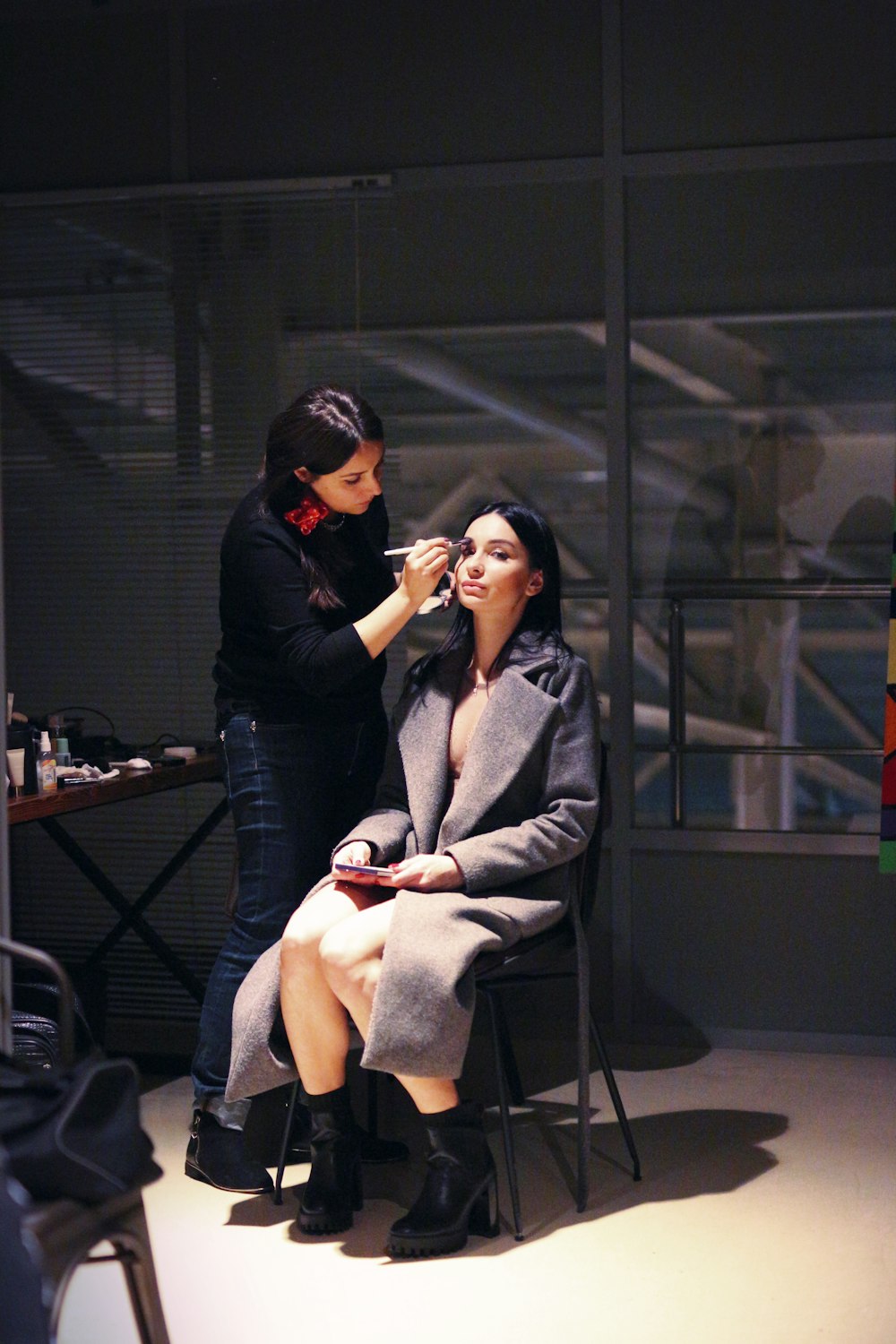 a woman getting her makeup done by another woman