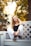 a beautiful young woman sitting on a white bench