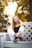 a beautiful young woman sitting on a white bench
