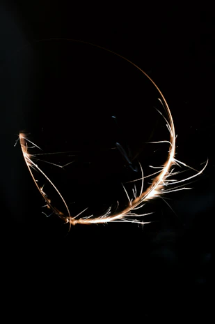 A glowing spark graphic symbolizing creativity and energy, set against a dark cosmic background.