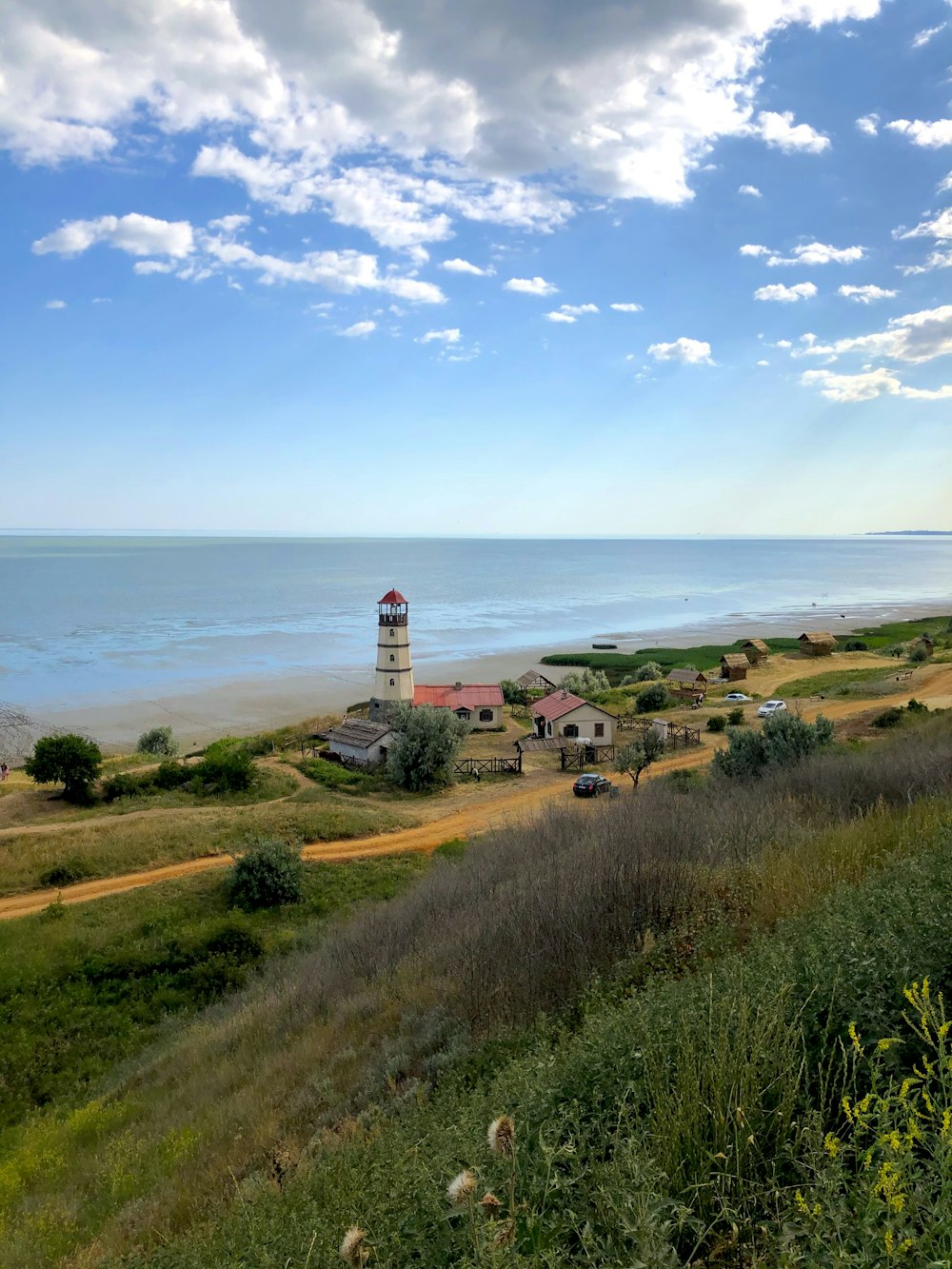 Ein Leuchtturm auf einem Hügel mit Blick auf den Ozean