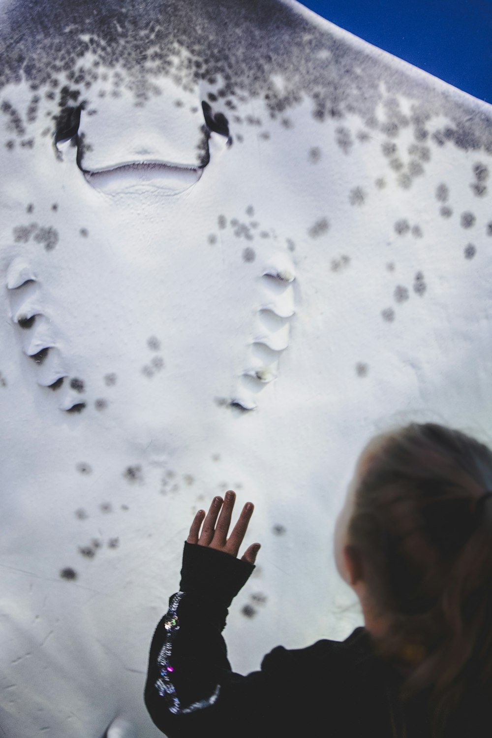 a girl is looking at a snow covered wall