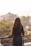 a woman standing on a balcony with her back to the camera
