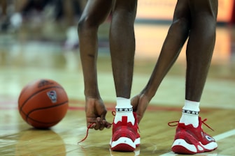 a close up of a basketball player tying his shoes