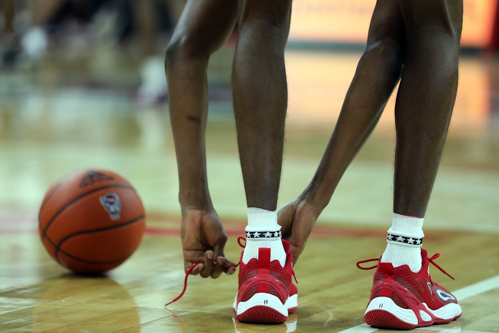 a close up of a basketball player tying his shoes