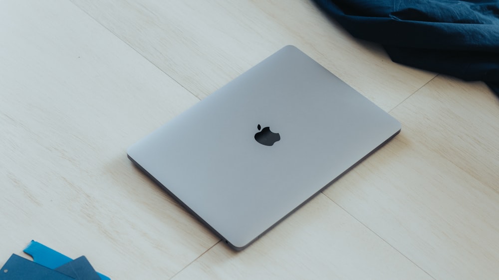 an apple laptop sitting on top of a wooden table