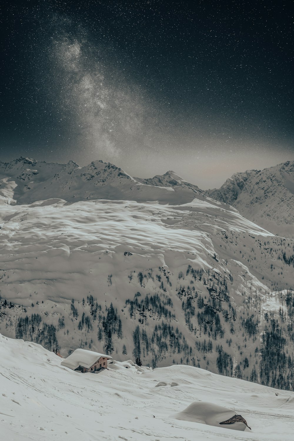 a person standing on a snow covered slope under a night sky