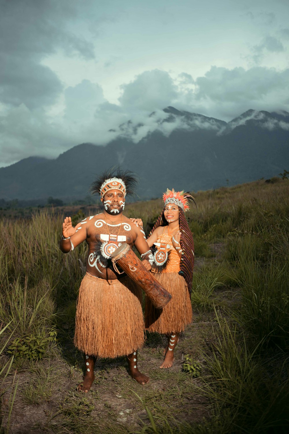 two people in native clothing standing in a field