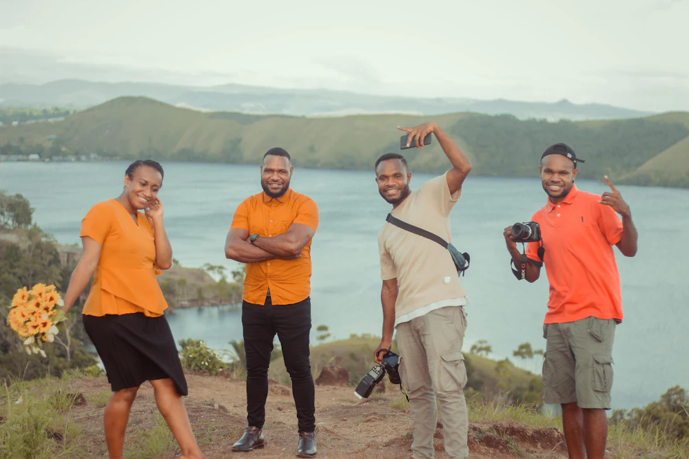 Four friends on a hilltop above a lake
