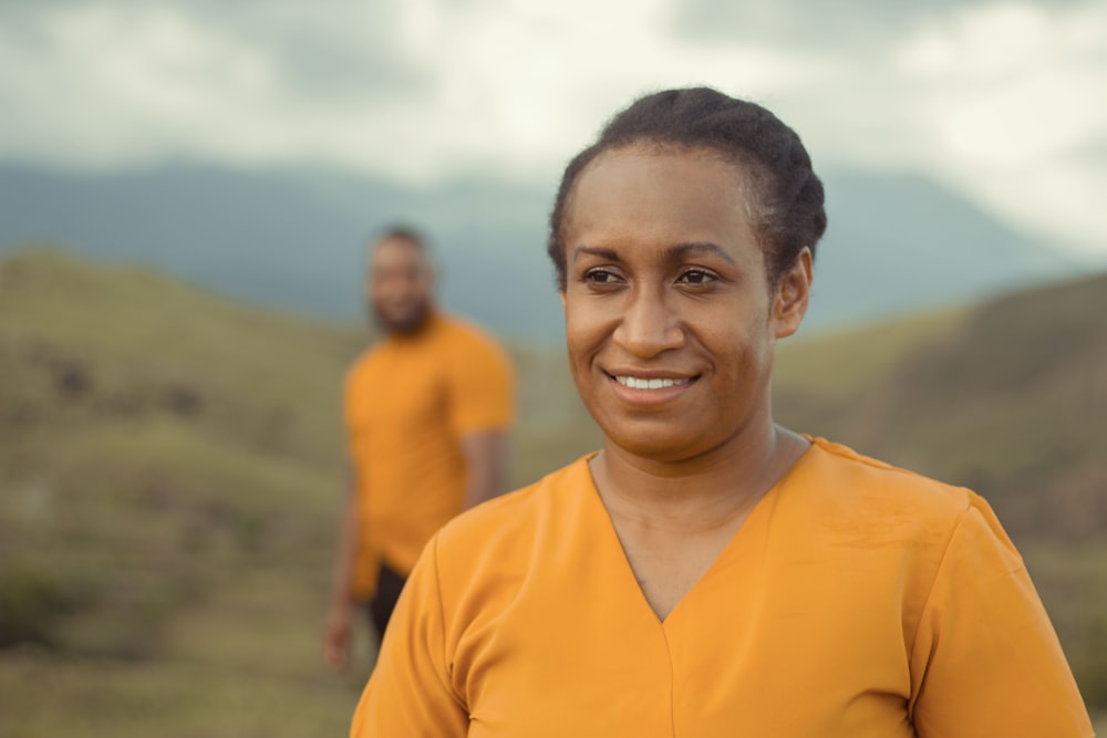 a woman in a yellow shirt standing next to a man