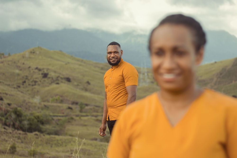 a man standing next to a woman in a field