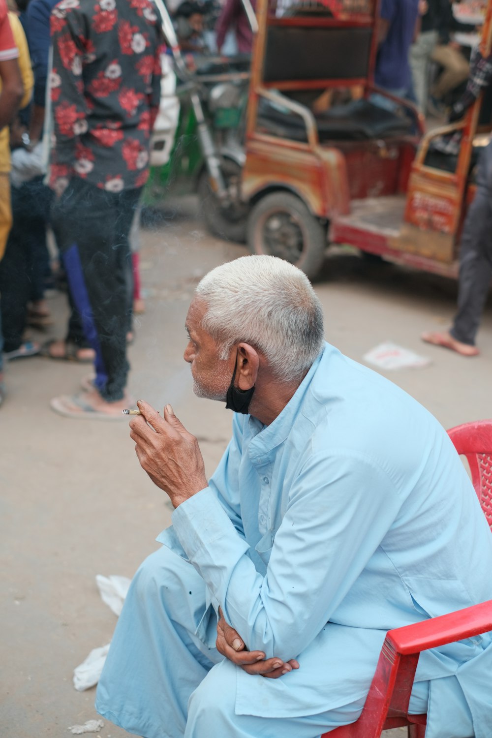 a man sitting on a red chair smoking a cigarette