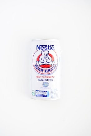 A white can of Nestlé Bear Brand ready-to-drink milk with a logo featuring a bear holding a glass. The can includes text in both English and Indonesian, indicating it is sterile milk.