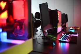 a desk with a keyboard, mouse and speakers
