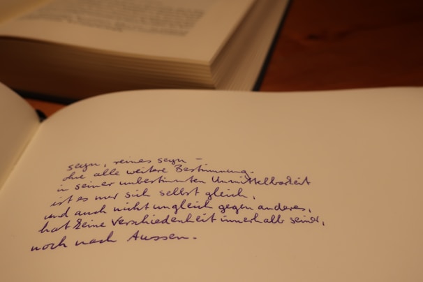Close-up of an open book with handwritten poetry on aged paper