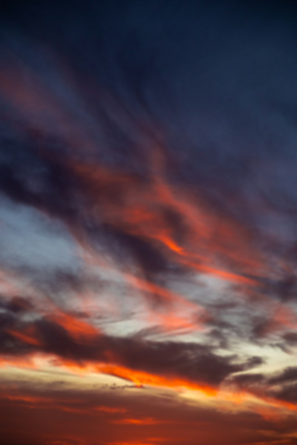 a plane flying in the sky at sunset