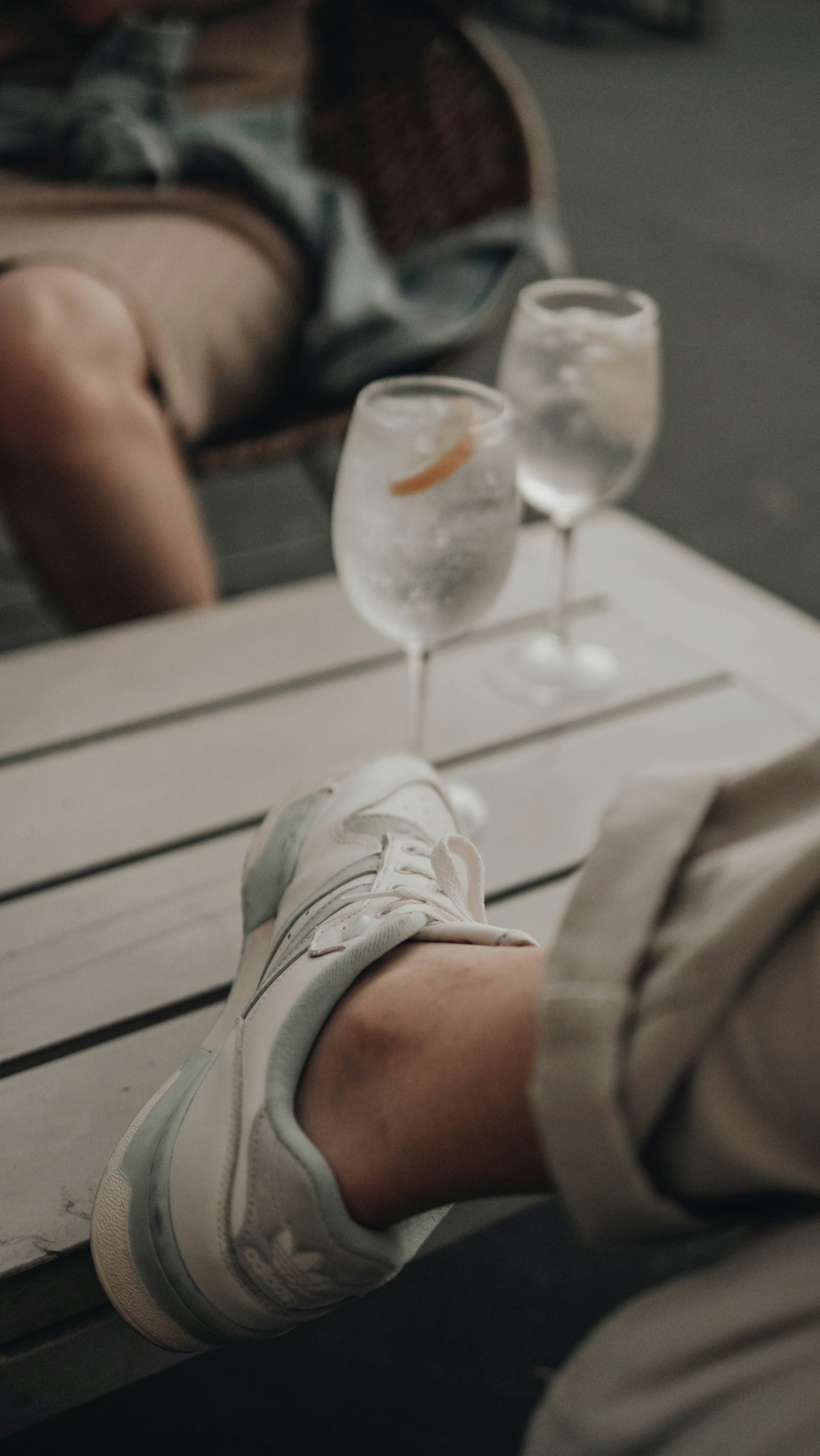 a person sitting at a table with two wine glasses