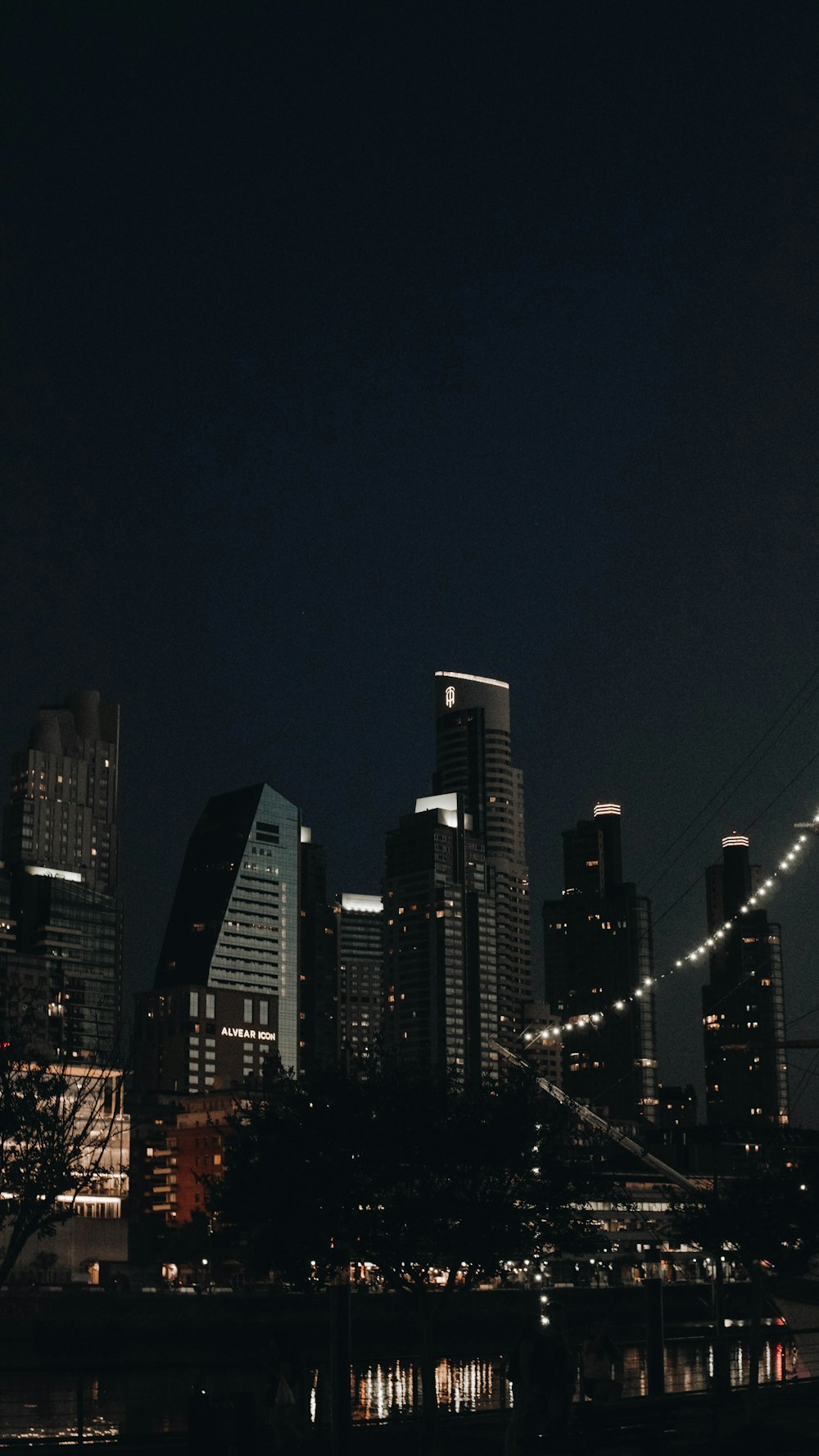 a night view of a city with a bridge in the foreground