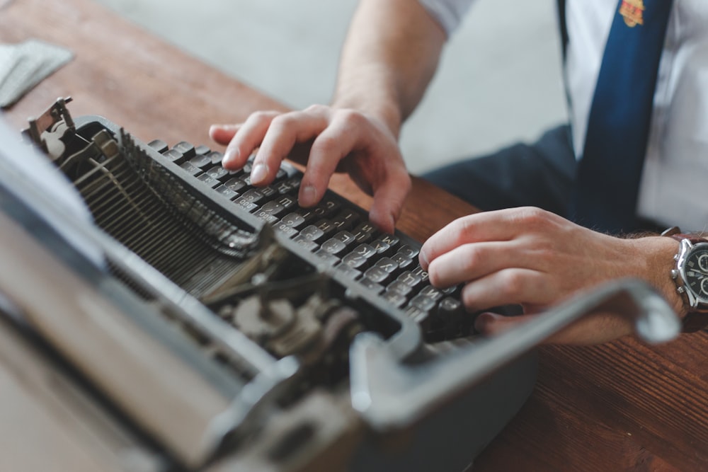 um homem digitando em uma máquina de escrever antiquada