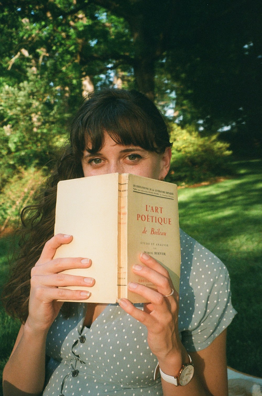 a woman holding a book in front of her face