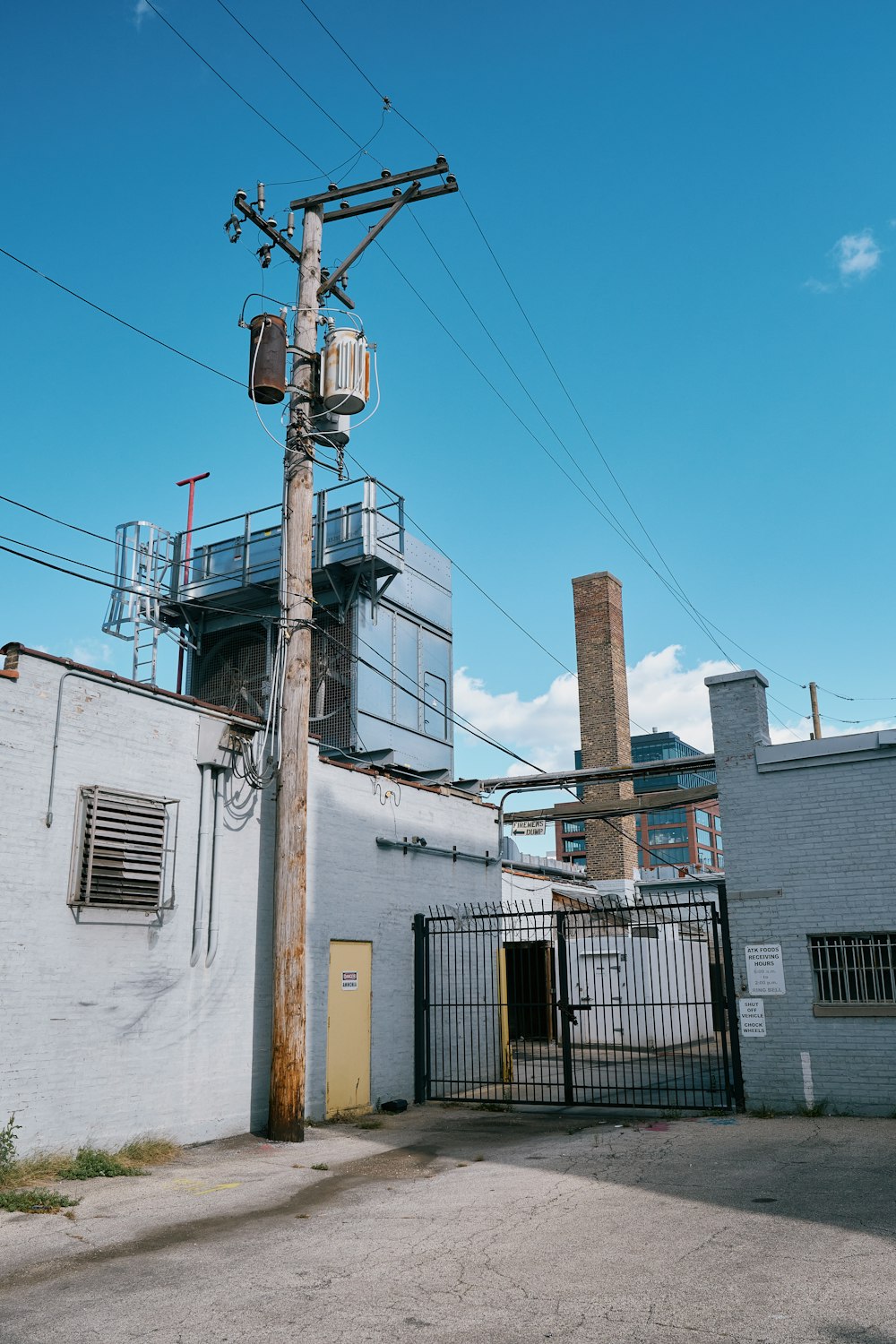 a tall white building sitting next to a metal fence