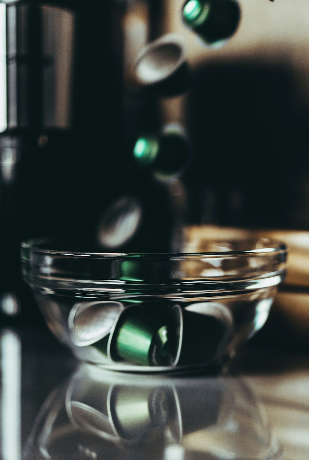 a bowl of green pills sitting on top of a counter