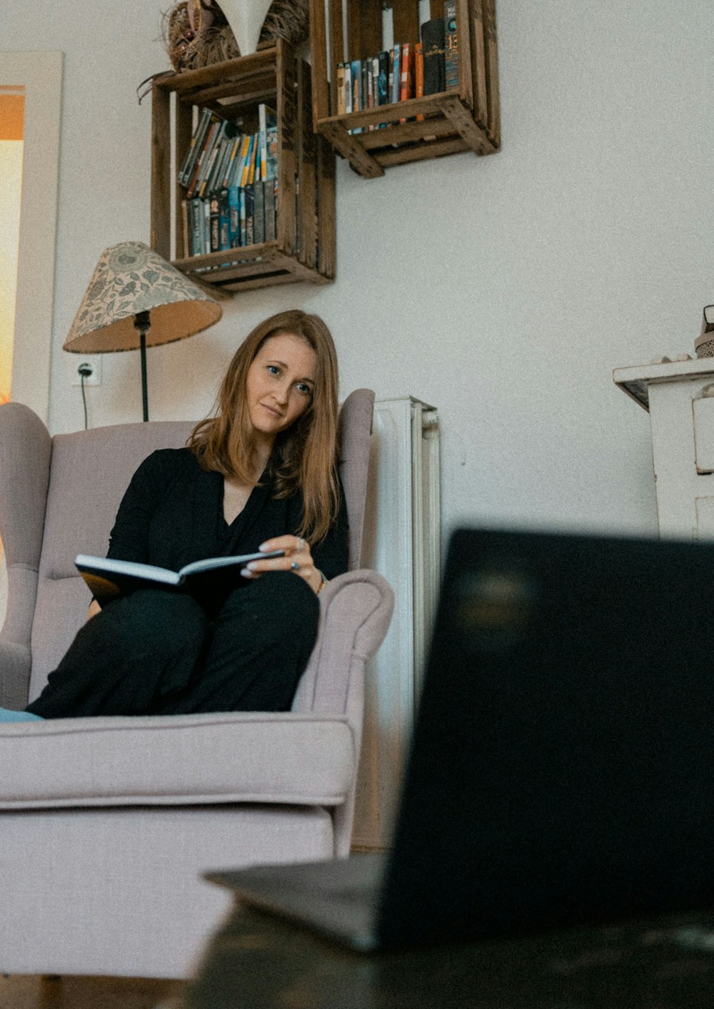 a woman sitting in a chair reading a book