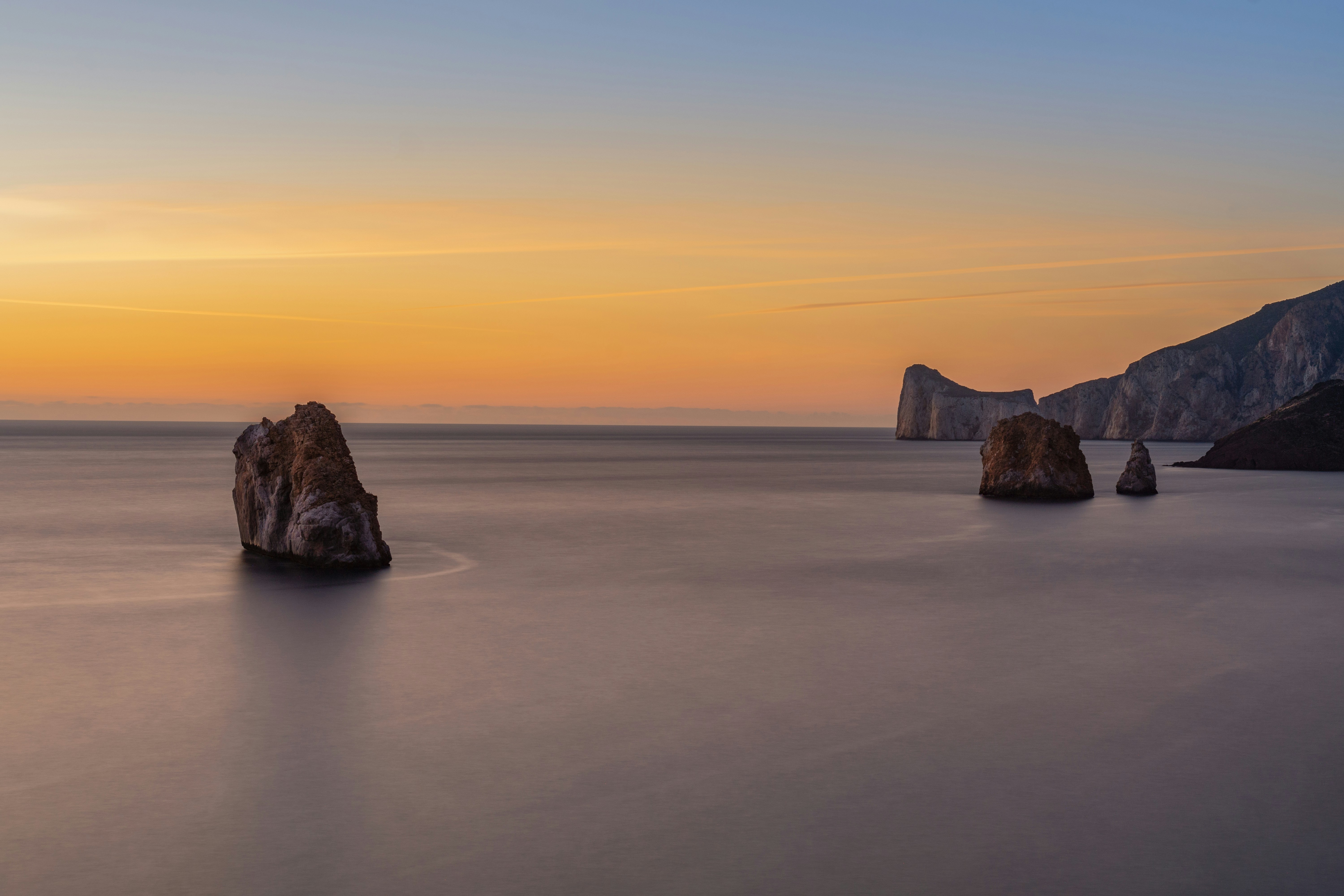 a group of rocks sitting in the middle of a body of water