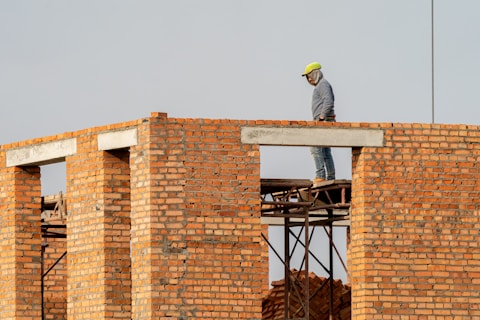 Um homem construindo paredes de alvenaria
