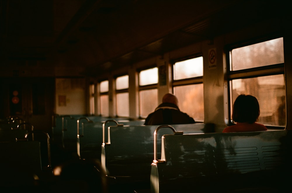 a couple of people sitting on a train next to each other