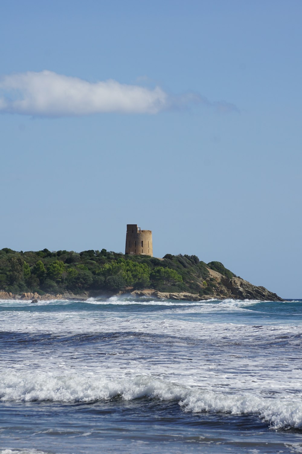 a tower on a small island in the middle of the ocean