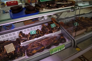 Display of various fresh meats neatly arranged in refrigerated cases.