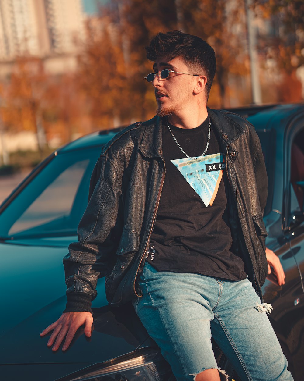 a man sitting on the hood of a car