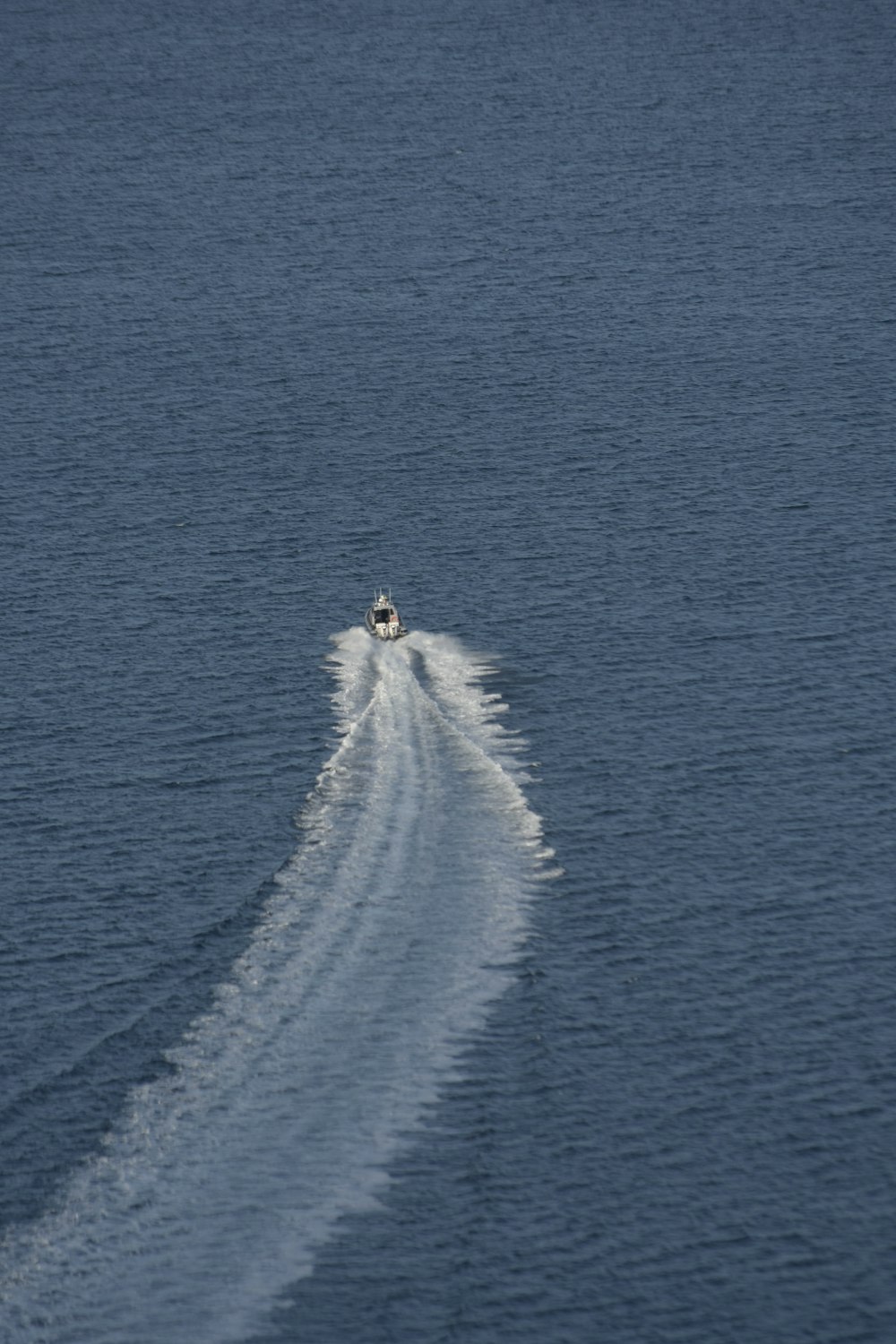 a speed boat speeding across a body of water