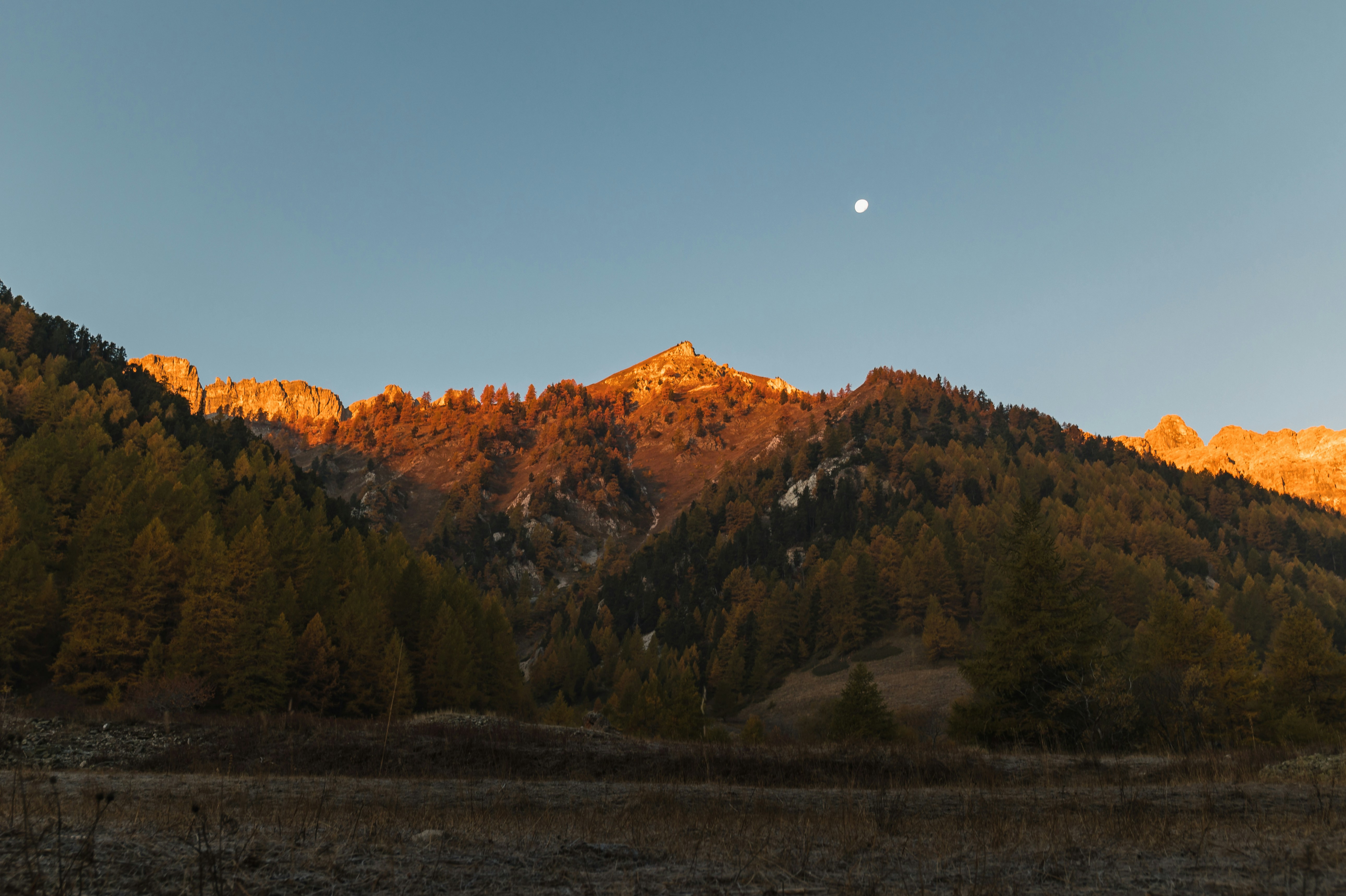 Una vista di una montagna con una luna nel cielo
