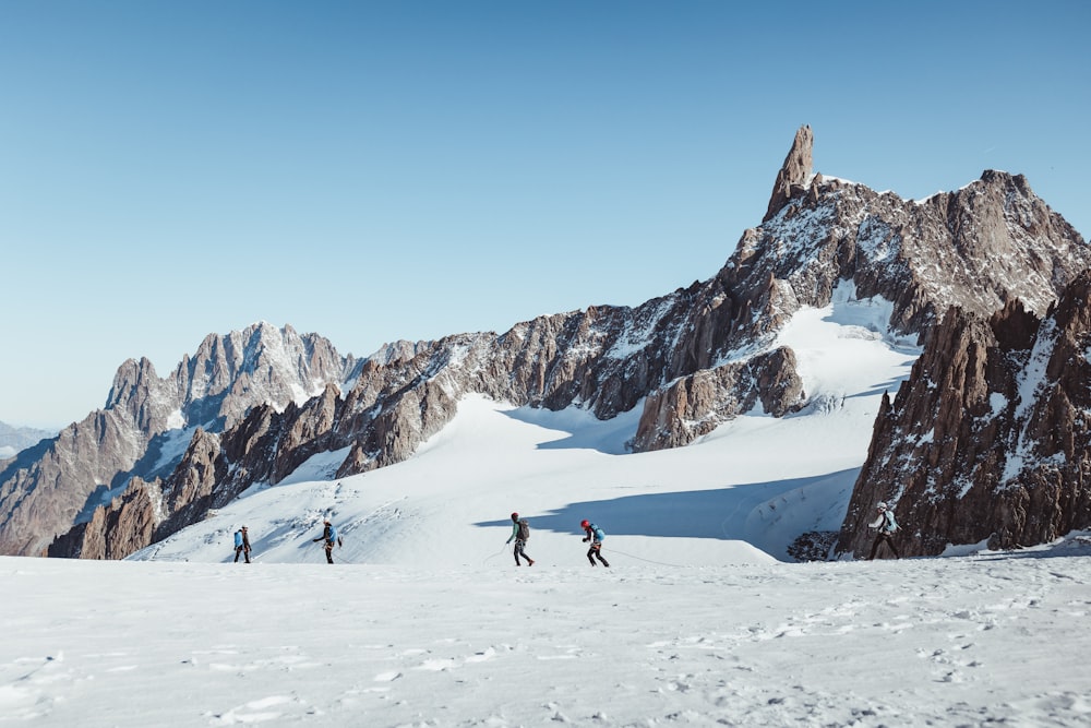 a group of people skiing down a snow covered mountain