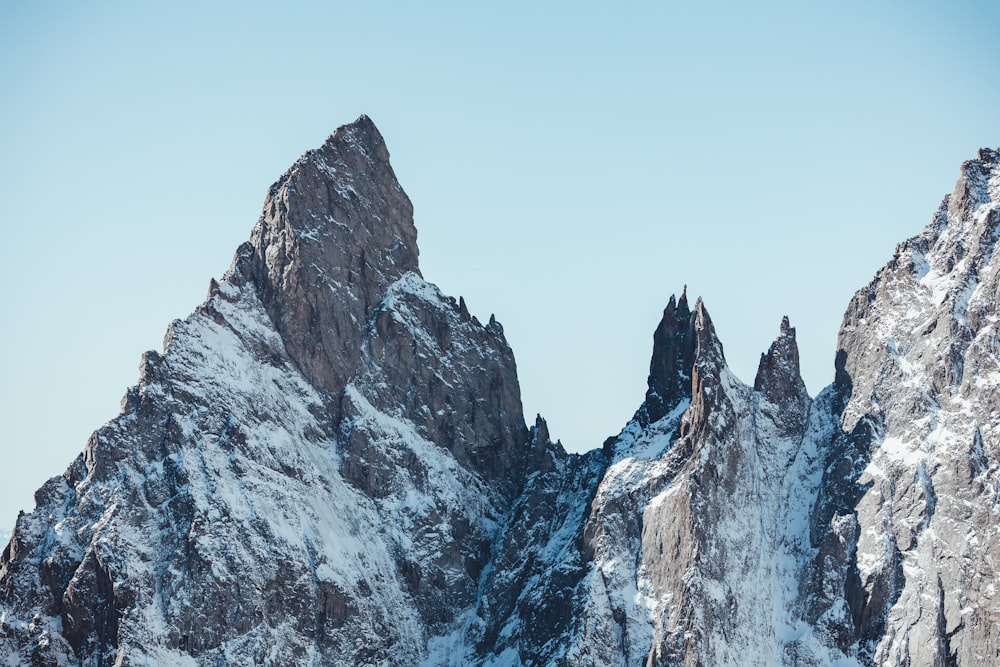Un gruppo di montagne coperte di neve sotto un cielo blu