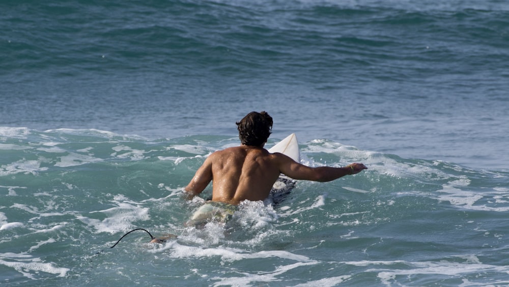 a man riding a surfboard on top of a wave in the ocean