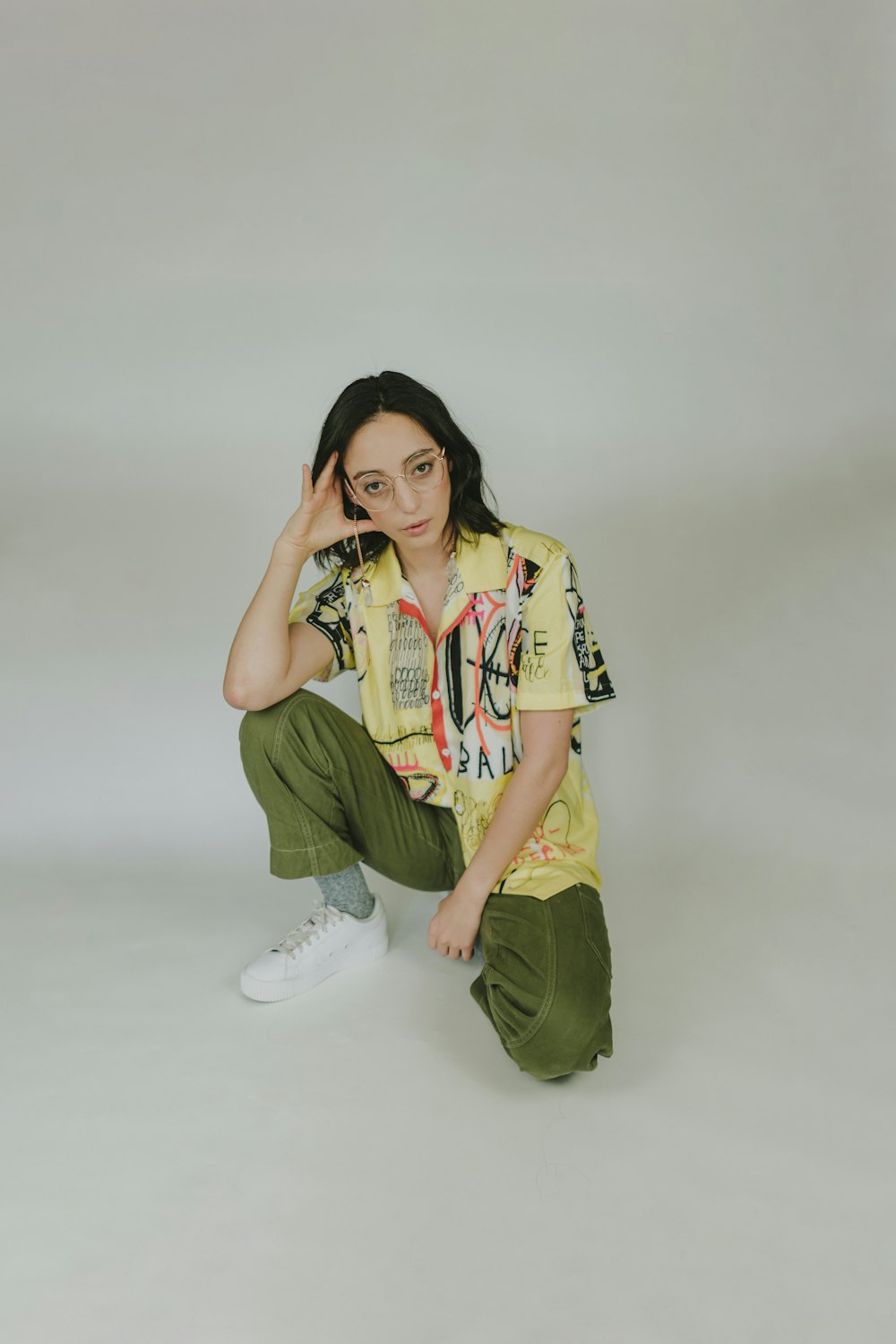 a woman sitting on the ground with her hand on her head