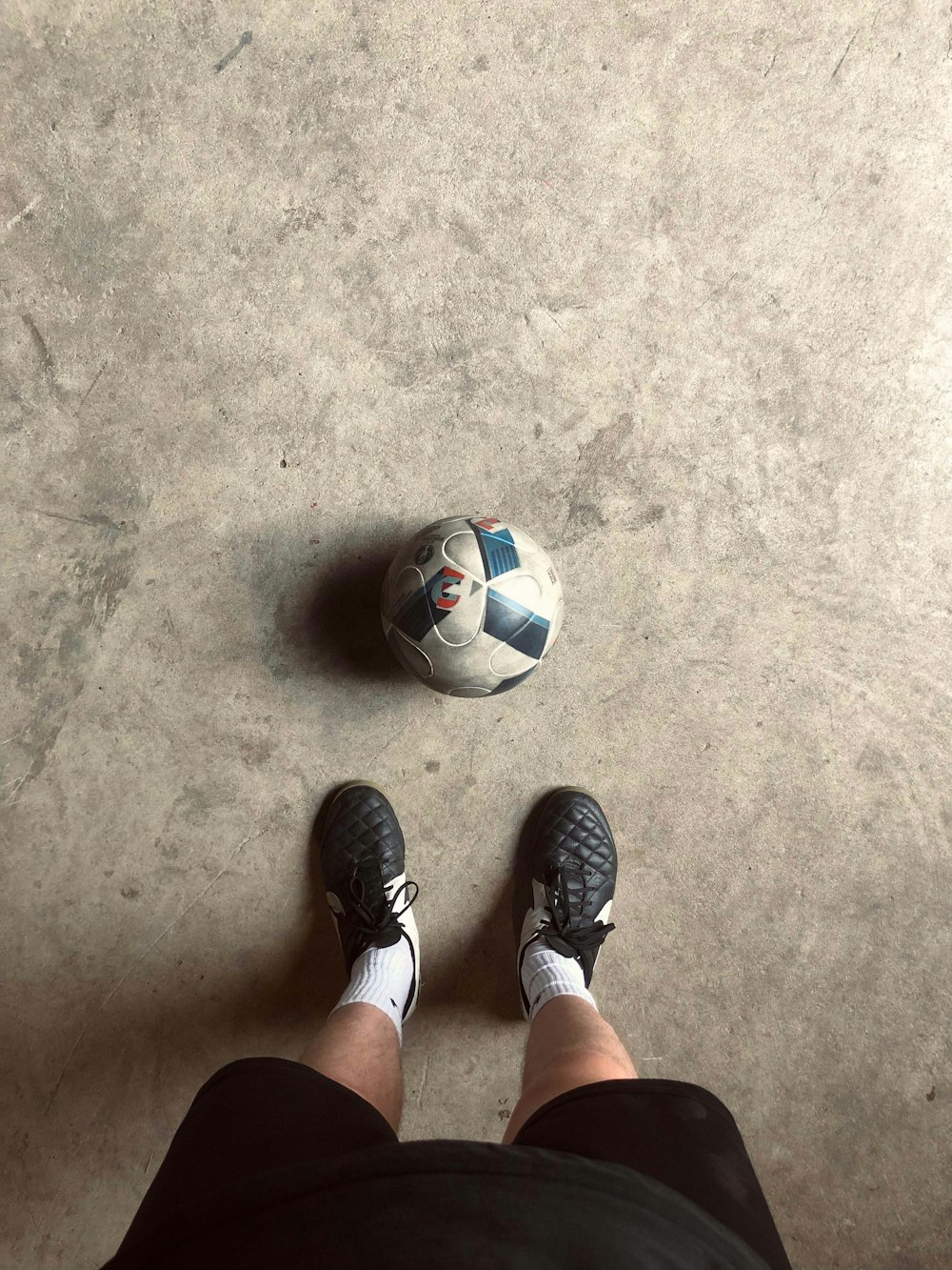 Una persona parada frente a un balón de fútbol