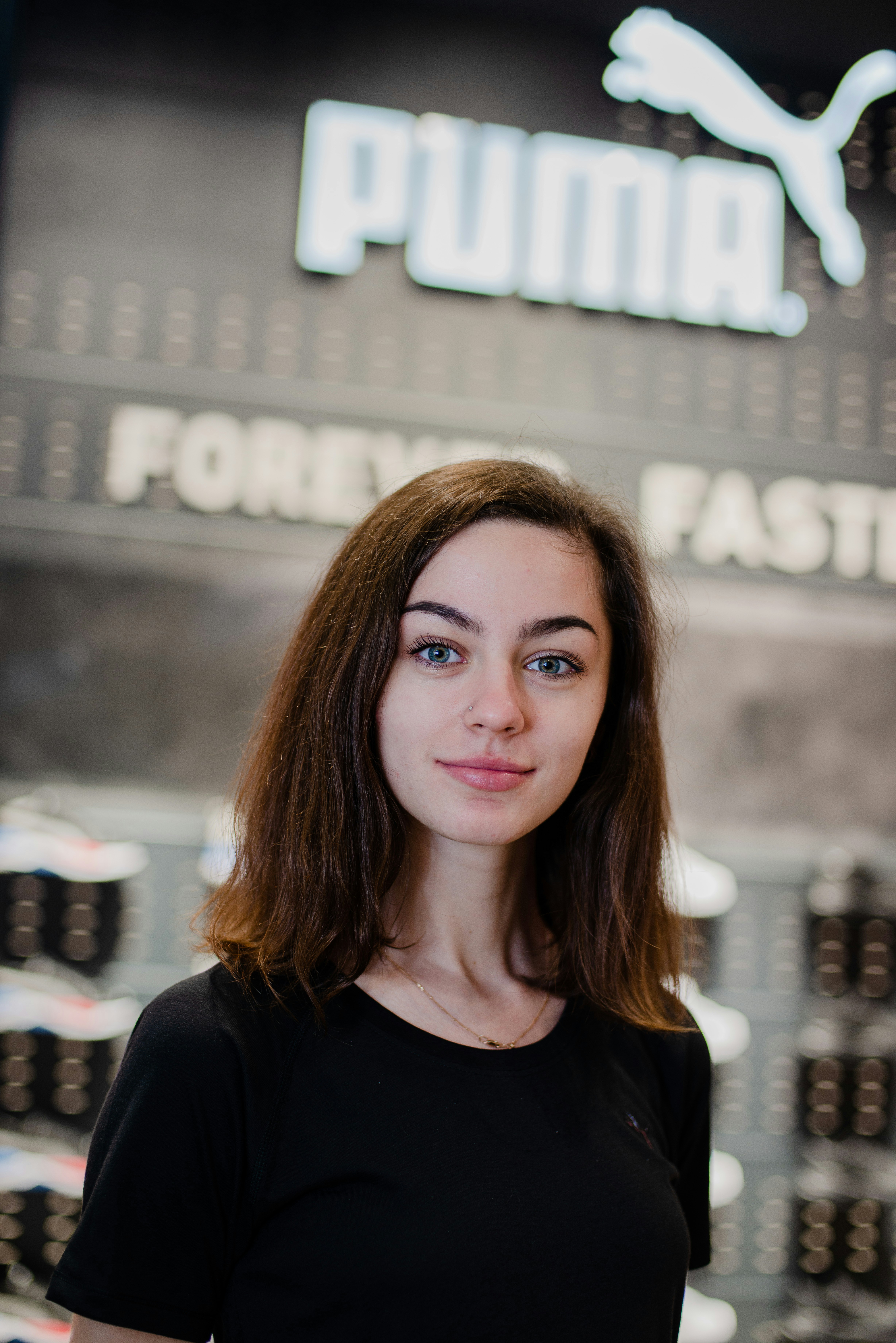 a woman standing in front of a display of shoes
