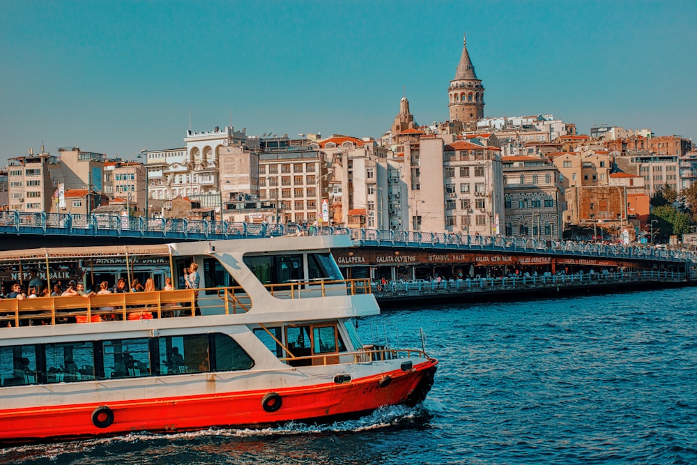 a red and white boat traveling down a river