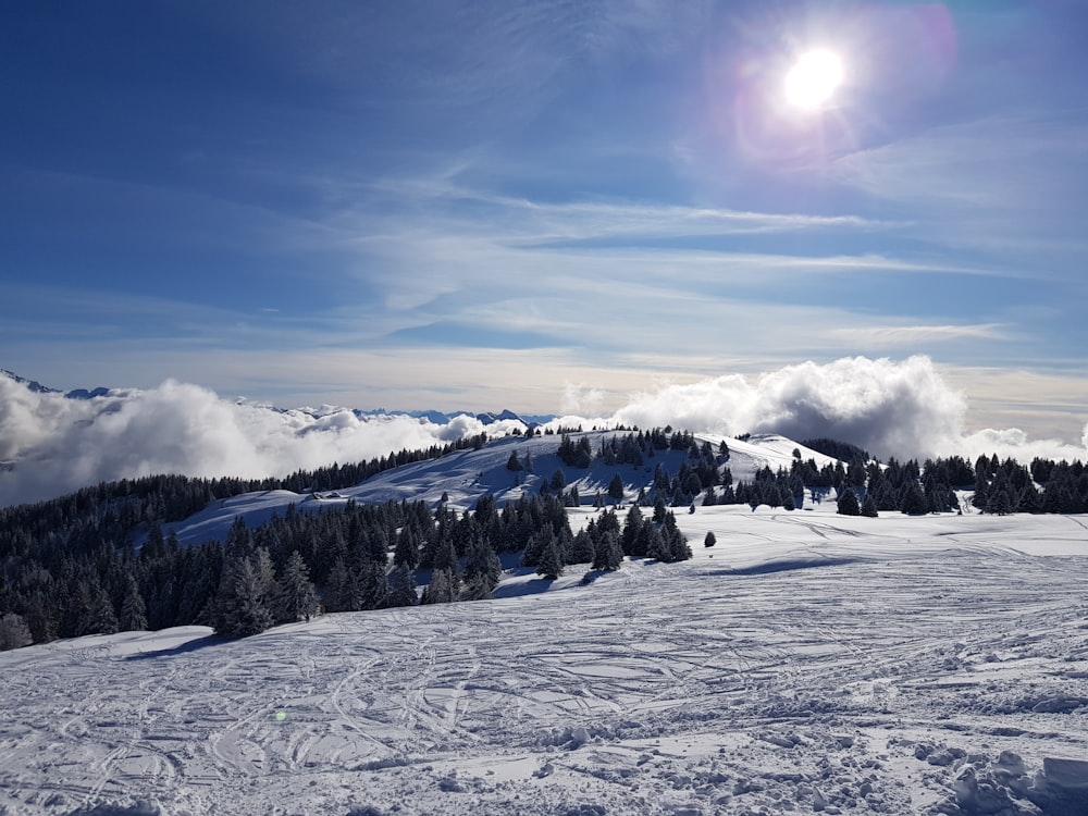 the sun is shining over a snowy mountain