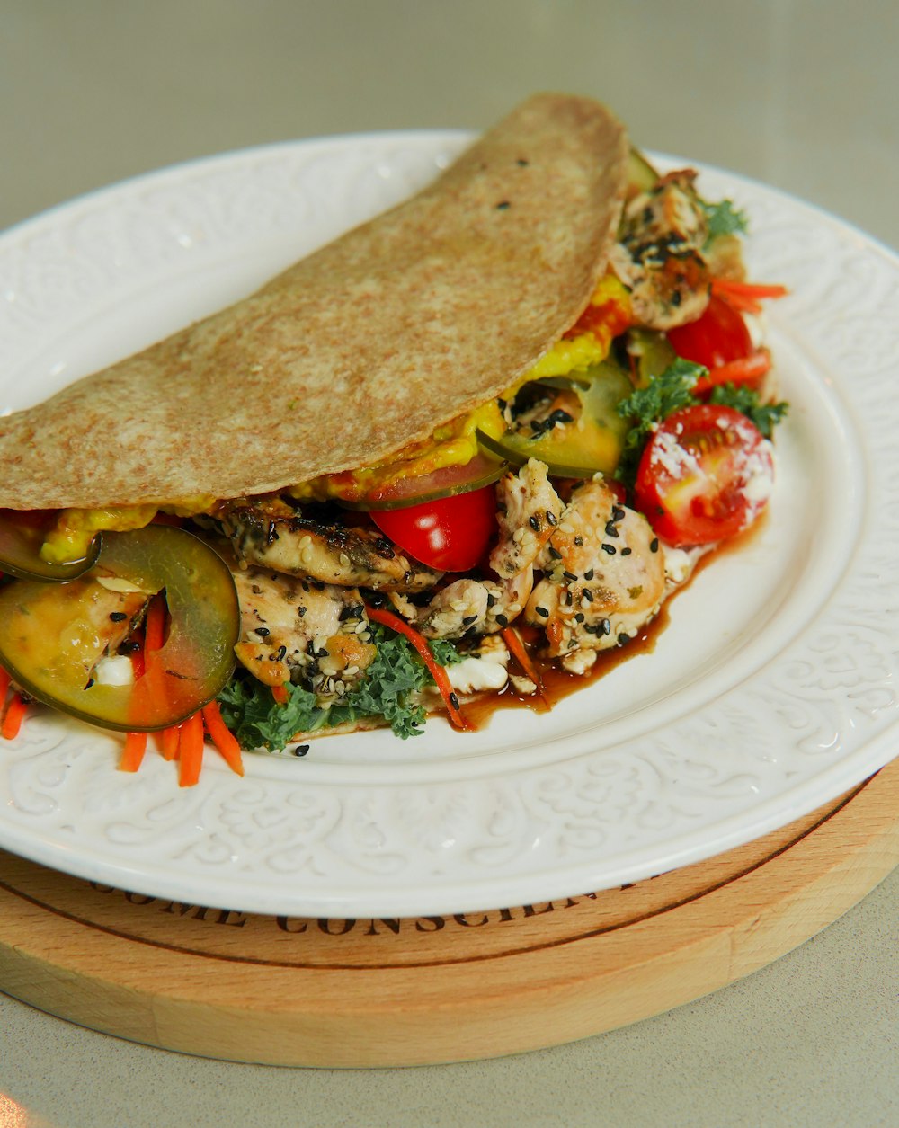 a white plate topped with a burrito filled with veggies