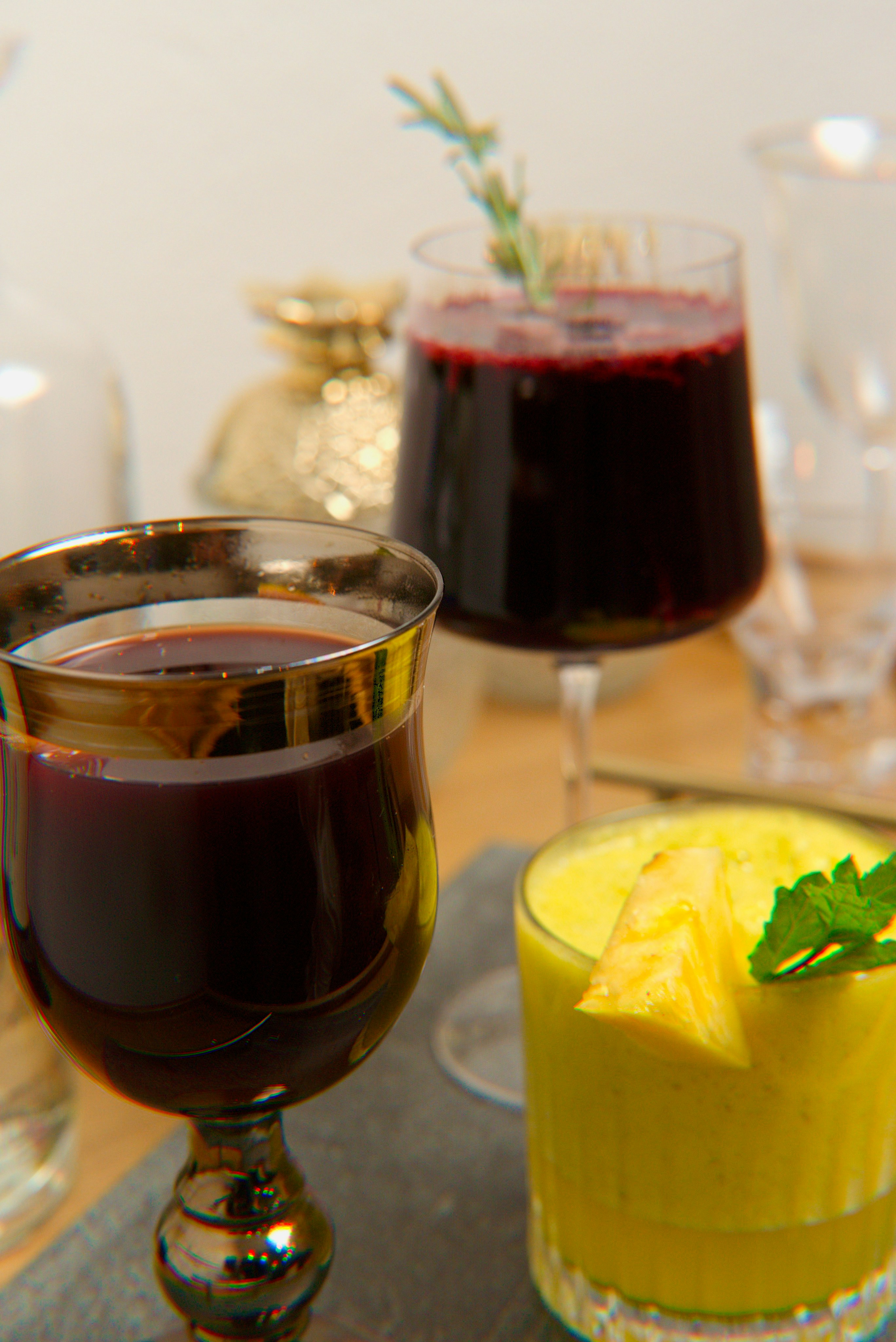 two glasses of different colored drinks on a table